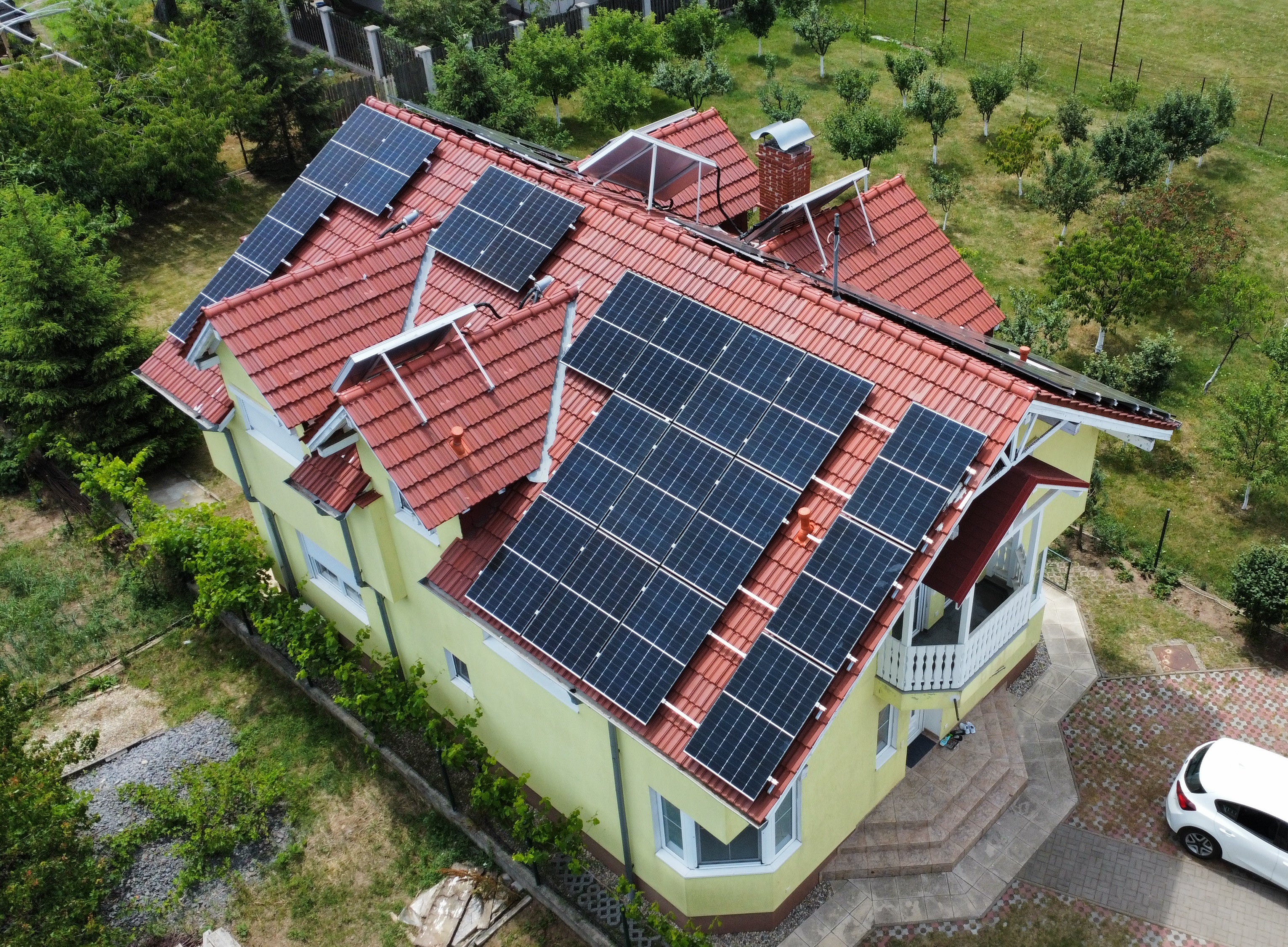 House with solar panels on the roof surrounded by greenery